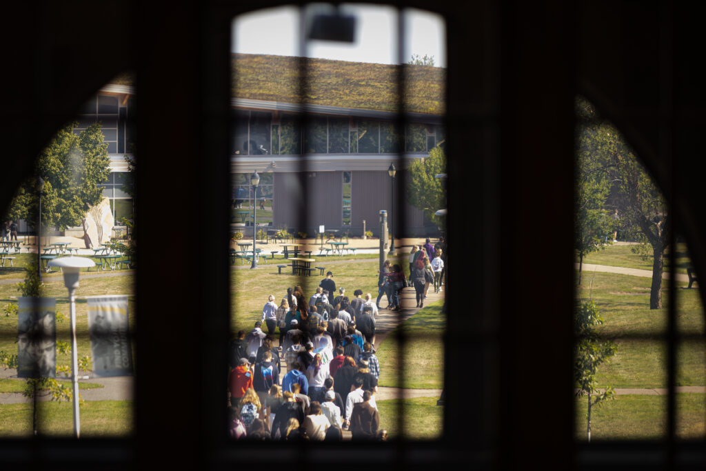 View of students walking on campus through window