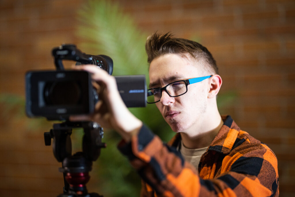 Student filming on large camera