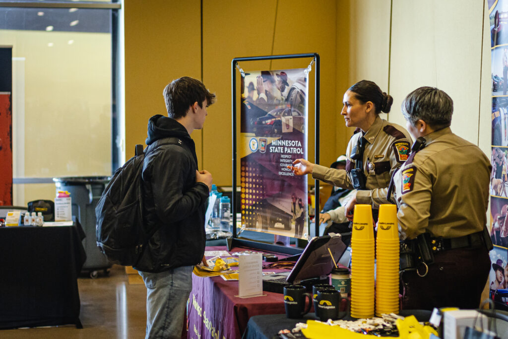 Minnesota State Patrol at career fair handing out swag to student