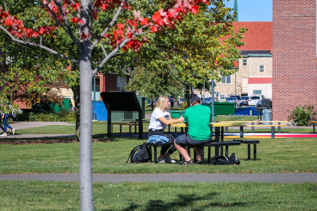 Students sitting on picnic table on campus