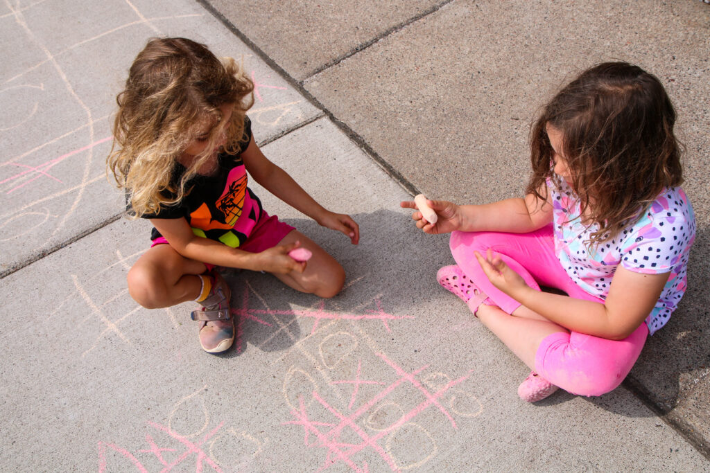 Picture of kids playing tic tac toe with sidewalk chalk