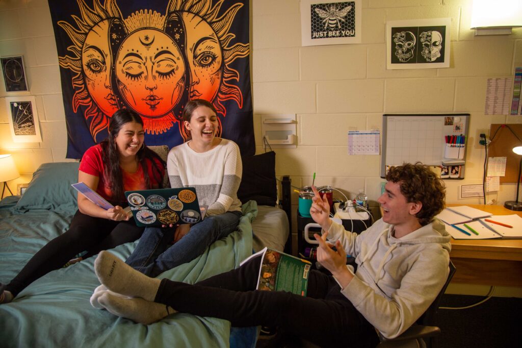 Friends laughing while they study in a dorm room of Ross Hawkes
