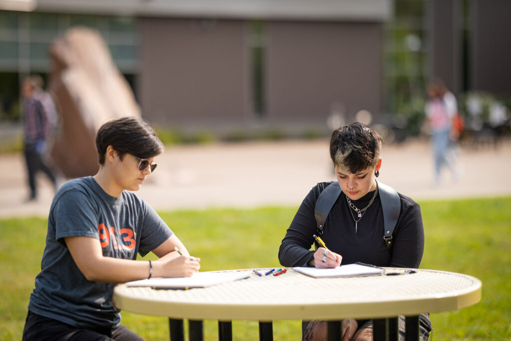 Students working outside on table
