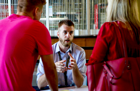 Peron explaining something to two other people