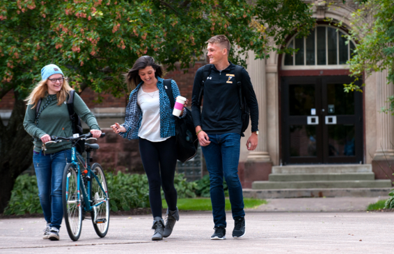 Three students walking on campus