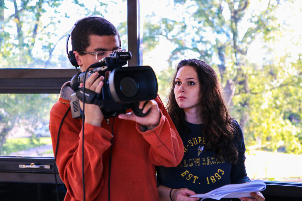 Two students using a large camera