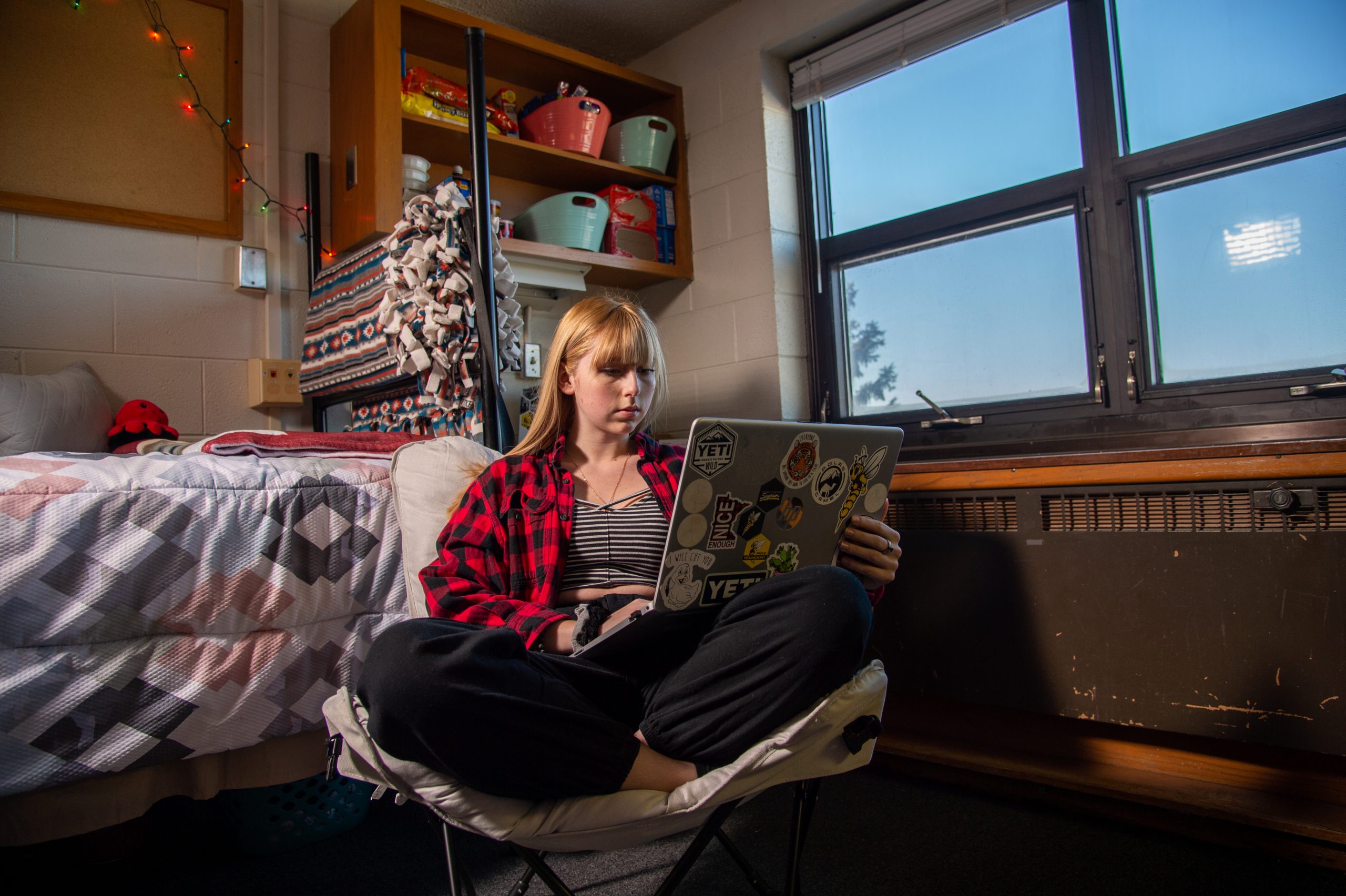 UWS student on her laptop in her dorm room.