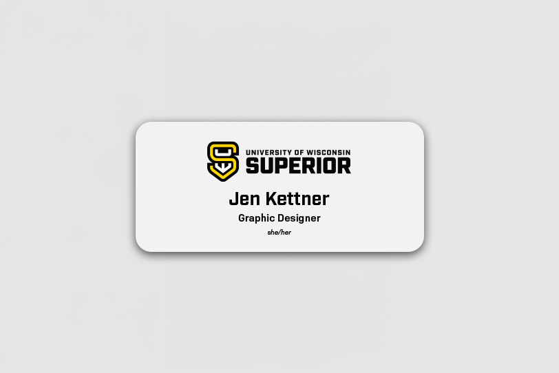 A name badge with the University of Wisconsin-Superior logo and text: Jen Kettner, Graphic Designer, she/her on a white background.