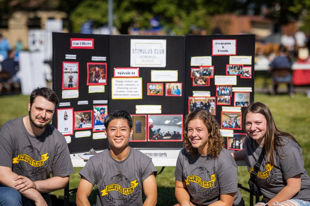 Four UW-Superior students in front of their Stimulus Club display