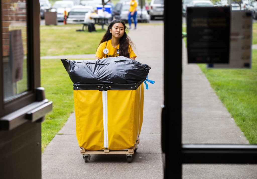 A student helping someone move into the residence halls